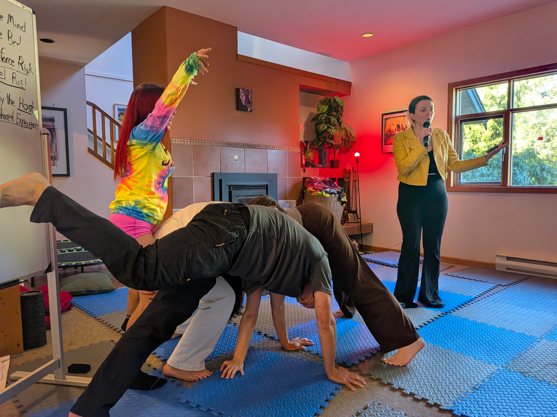 Participants making a playful human bridge during a movement game in the Joymaker Mansion
